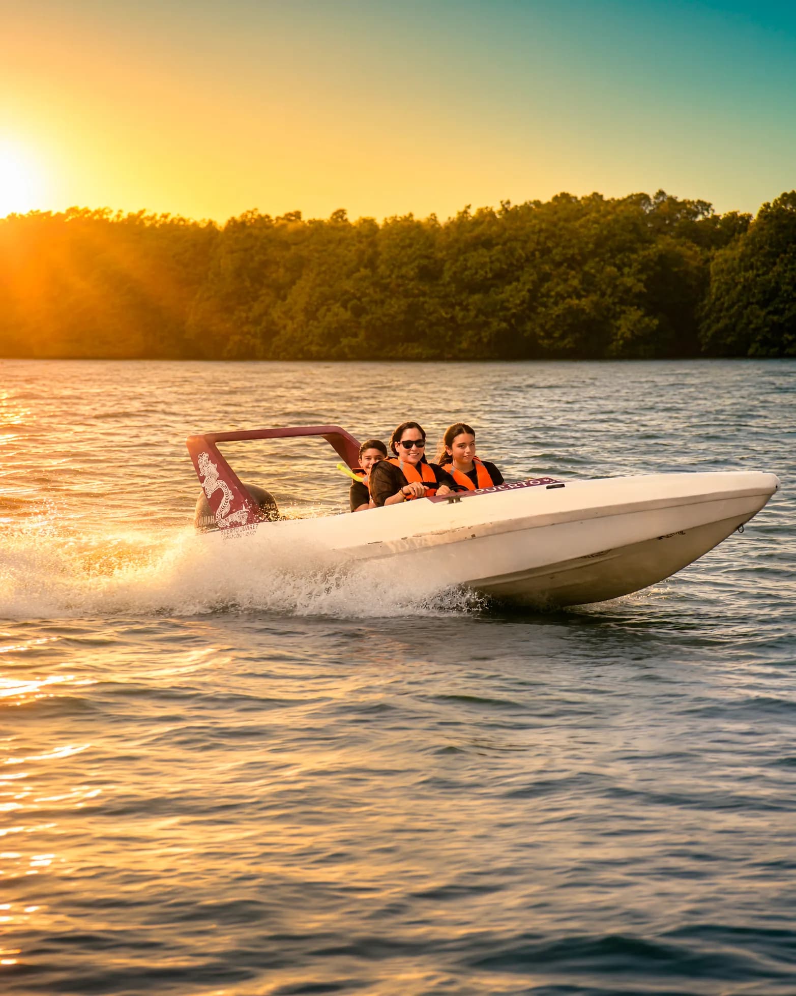 Family driving a speedboat at sunrise